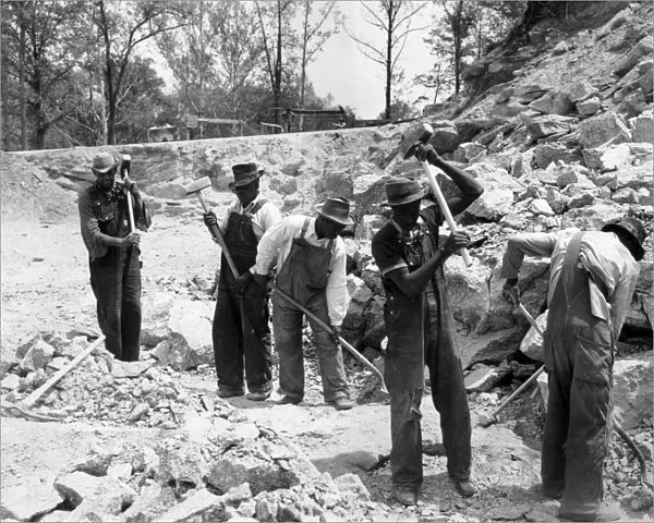 PRISONERS. Five African American convicts breaking up rocks for road construction
