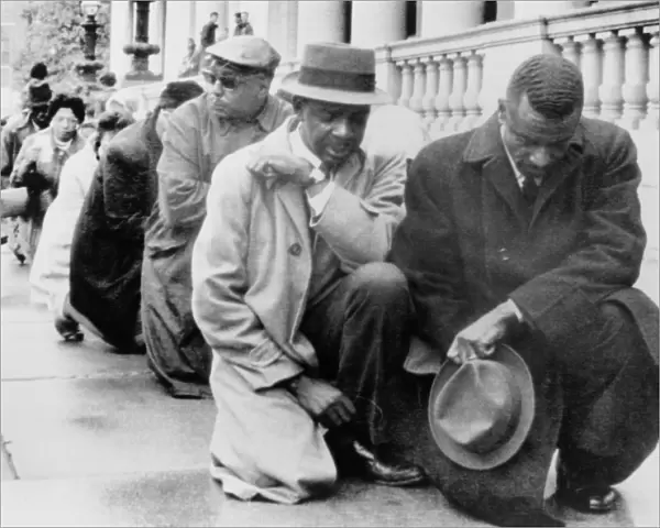 CIVIL RIGHTS PROTEST, 1963. African American protesters kneel on the sidewalk outside