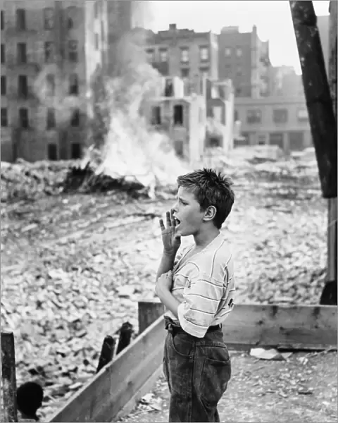 NEW YORK: SLUM, 1961. A boy yelling, backed by the remnants of a demolished slum