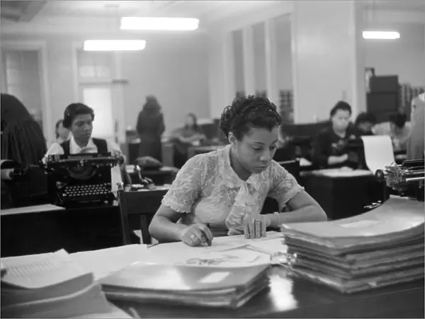 INSURANCE COMPANY, 1941. Employees at work at an African American insurance company in Chicago