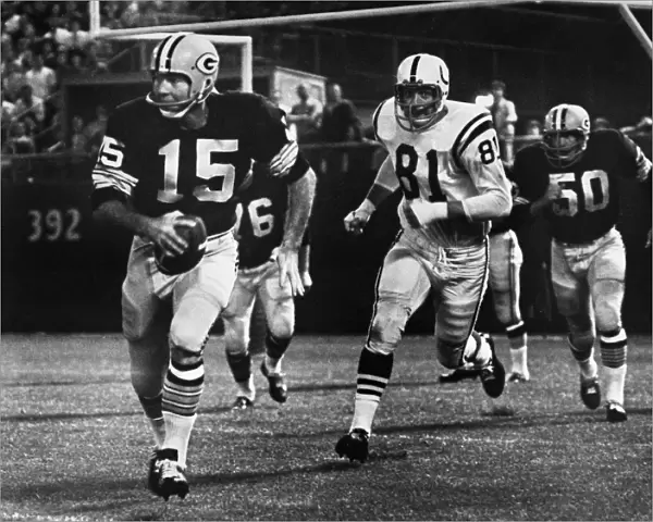 FOOTBALL GAME, 1966. Quarterback Bart Starr of the Green Bay Packers attempting to run for a first down against the Baltimore Colts after failing to find an open receiver, during a game at County Stadium, Milwaukee, Wisconsin, 10 September 1966