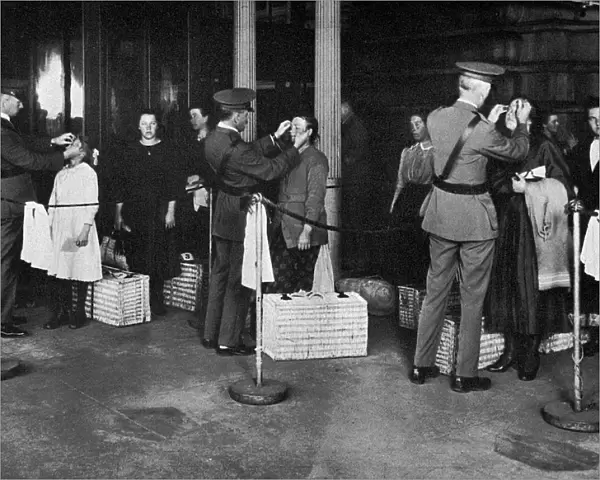 ELLIS ISLAND: EXAMINATION. Immigrants being examined for eye diseases at Ellis Island, early 20th century