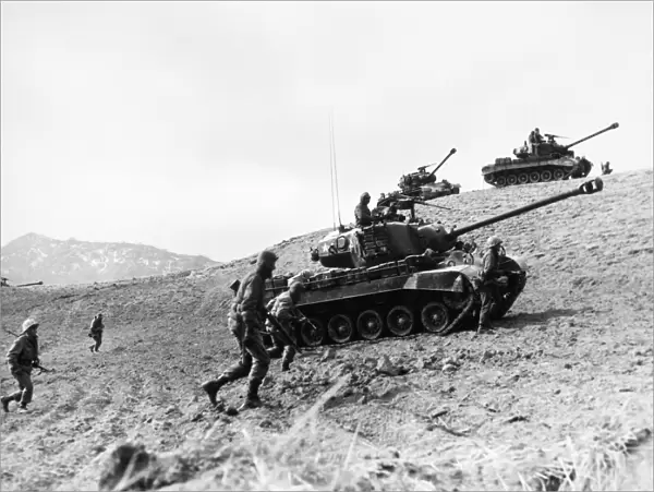 KOREAN WAR: INFANTRYMEN. American Infantrymen supported by tanks advance up a hill in Korea, 1952
