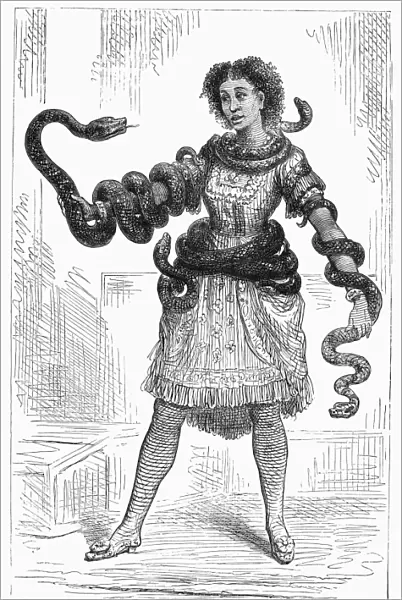 SNAKE CHARMER, 1878. Lualla, the Abyssinian snake charmer, at the Royal Aquarium, London. Wood engraving, 1878