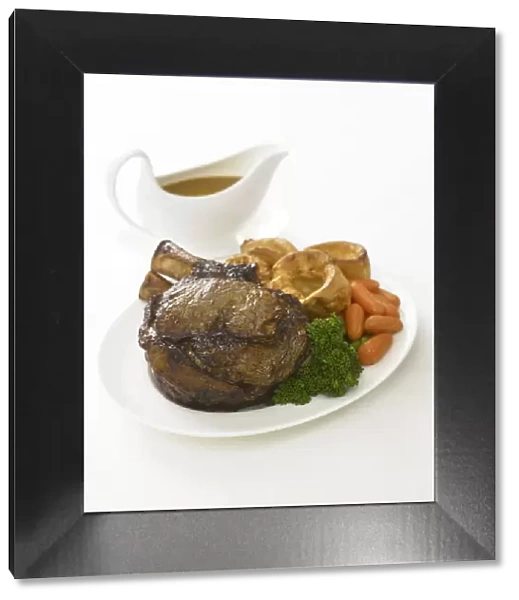 Roast beef served with Yorkshire pudding, carrots and broccoli, on a plate, gravy boat nearby, close-up