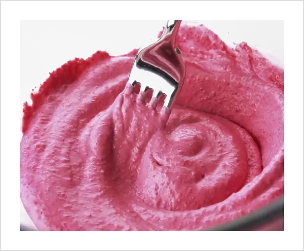Close-up of beetroot mayonnaise being stirred using a metal fork