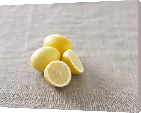 Two whole lemons and a lemon sliced in half