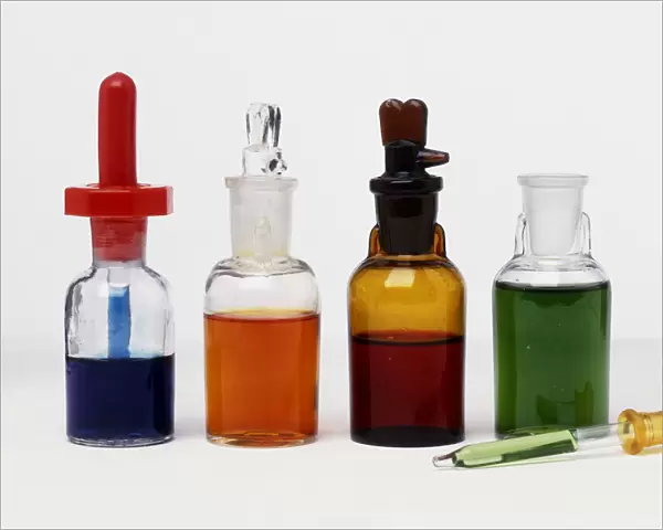 Four bottles of different coloured liquids for chemical stain tests, and a pipette