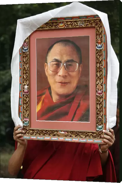 Buddhist holding a picture of the DalaatA