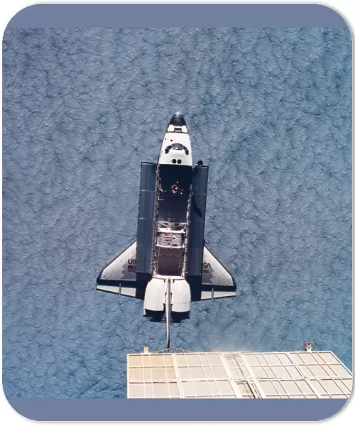 Elevated view of the space shuttle orbiting above earth with its cargo bay open