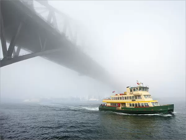 Iconic Sydney Ferry passing the Bridge on a misty day