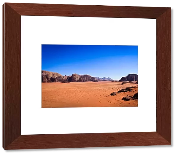 Panoramic view of Wadi Rum with clear blue sky background and some rock boulders