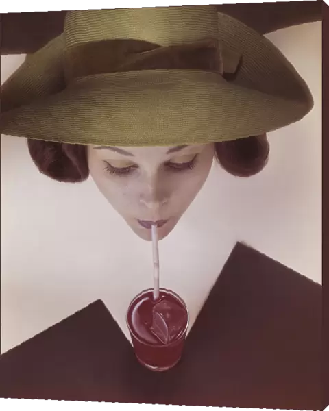 Woman drinking juice by drinking straw, close-up