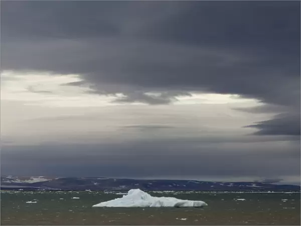 Iceberg floating in Palanderbukta fjord during strong winds and storm clouds, Nordaustlandet, Svalbard Archipelago, Svalbard and Jan Mayen, Norway