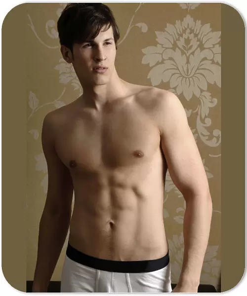 Young man wearing underwear standing in front of nostalgic wallpaper