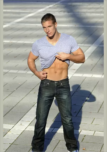 Young man undressing in the sunshine