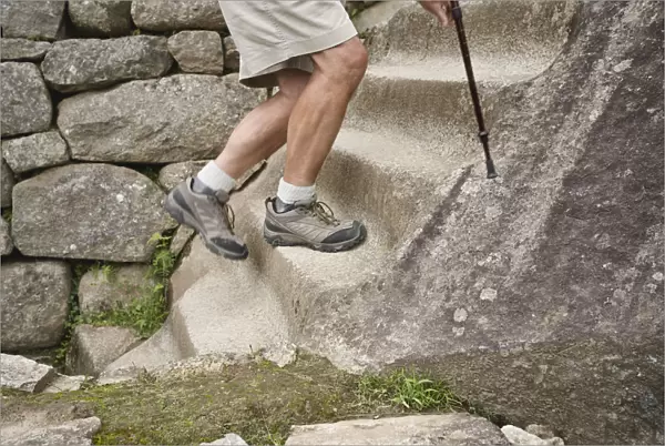 Peru, Machu Picchu, man climbing stone steps, low section