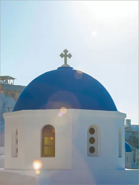 Sunlight over blue domed church, Santorini, Greece