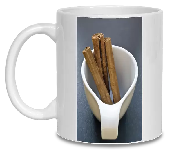 Sticks of cinnamon in small white cup credit: Marie-Louise Avery  /  thePictureKitchen