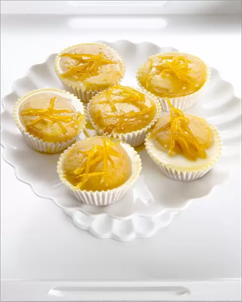 Six lemon drizzle fairy cakes on white cake stand credit: Marie-Louise Avery  /  thePictureKitchen