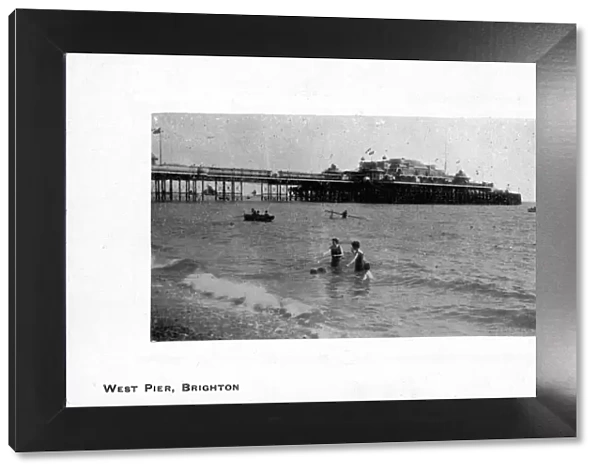 Some people swimming in the sea near West Pier, Brighton, East Sussex, England