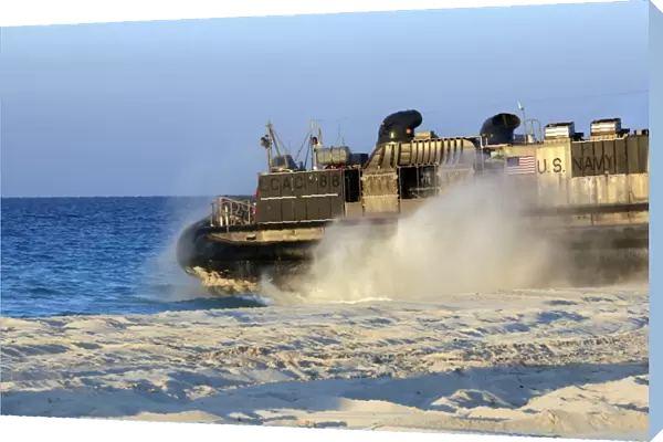 An assault craft heads back to sea after dropping off cargo during an offload