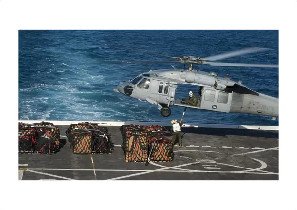 Marines attach cargo to an MH-60S Sea Hawk helicopter