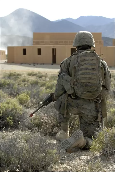 A U. S. Marine watches for simulated insurgents in a military operation on urban terrain