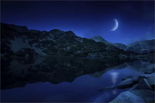 Moon rising over tranquil lake and mountains in Pirin National Park, Bulgaria