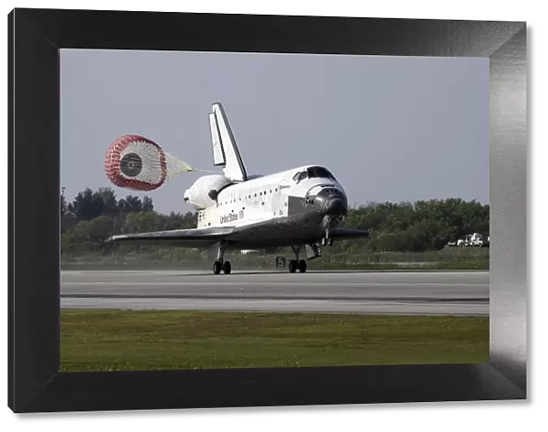 With drag chute unfurled, space shuttle Discovery lands on Runway 33 at the Shuttle