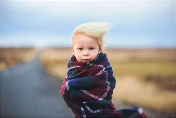 Wind. Beautiful child, standing on a road on a very windy day