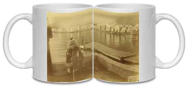 Unidentified young girl standing on wharf, with buildings along waterfront...1894 or 1895. Creator: Alfred Lee Broadbent