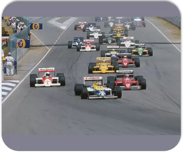 Formula One World Championship: Ricardo Patrese Williams FW11B heads the field into Turn 1