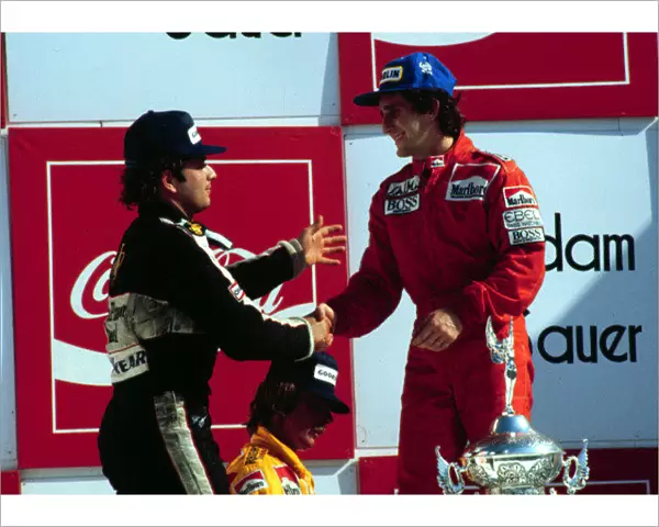 1984 BRAZILIAN GP. Elio de Angelis congratulates race winner Alain Prost on the podium