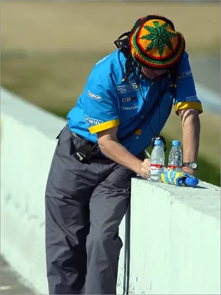 Formula One Testing: A Renault engineer takes some times out on the circuit with some unusual head gear