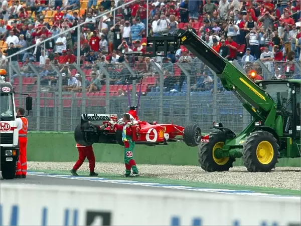 Formula One World Championship: The Ferrari F2002 of Rubens Barrichello is removed from the track after he spun off at the final corner at the