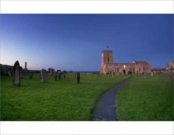 A Path Leading Through A Cemetery To A Church Building; Bamburgh Northumberland England