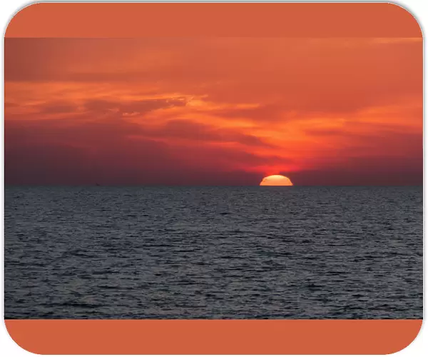 Dramatic Red Sky With The Sun Setting Under The Ocean And Horizon; Paphos, Cyprus