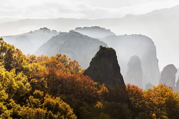 Low Cloud Around The Rugged Cliffs With Foliage In Autumn Colours; Meteora, Greece