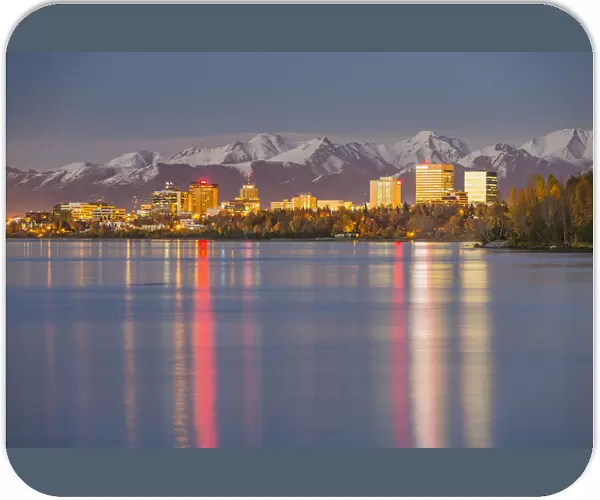 The Anchorage Skyline With The City Lights Reflected In The Water Of Knik Arm At High Tide, Snow Covered Chugach Mountain In The Background, Knik Arm, Cook Inlet, Anchorage Southcentral Alaska, Usa