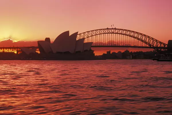 Australia, New South Wales, Opera House and Harbor Bridge at sunset; Sydney