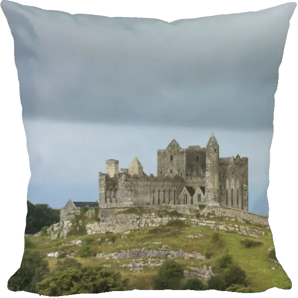 Rock of Cashel on the hilltop against a cloudy sky and Hore Abbey below, County Tipperary, Ireland