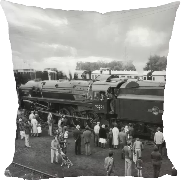 People viewing steam train Evening Star by engine shed; England