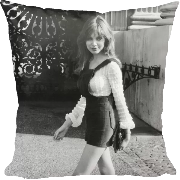Model and horror film actress Madeline Smith poses wearing hot pants suit with knee high