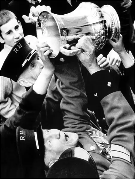 Chelsea Pensioners get a hand on the FA Cup as Dave Webb hands it to them during