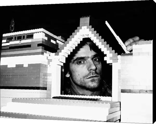 Jeremy Irons Actor with his head inside model house built from lego bricks which was used