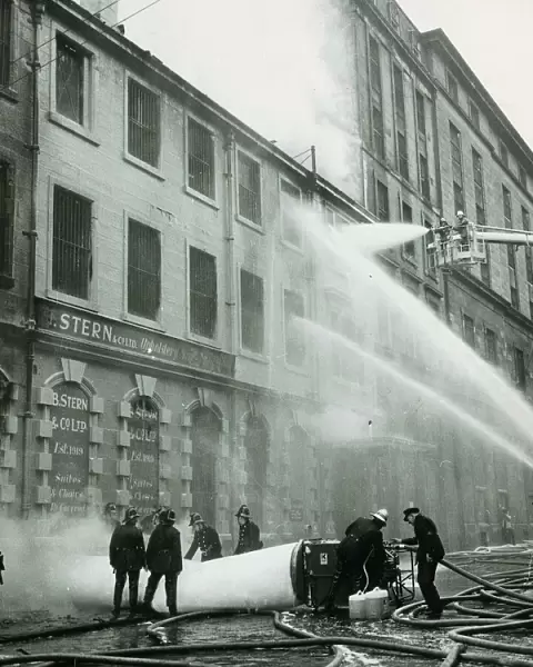 Firemen hosing down a building after a warehouse fire on James Watt Street in Glasgow