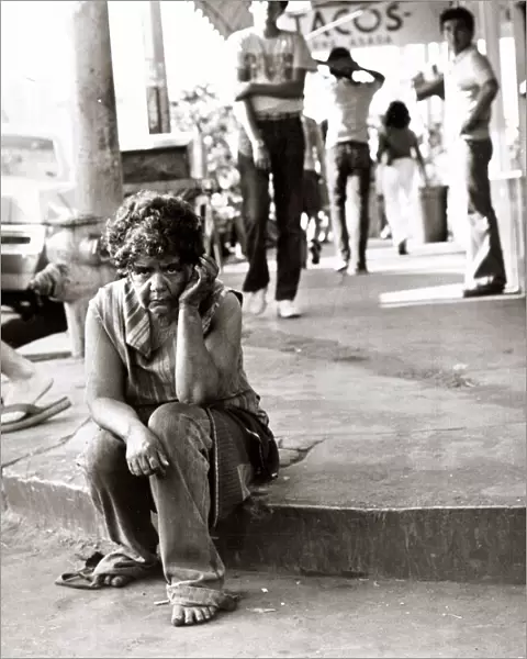 Street scene in Tijuana, Mexico - August 1977, homeless woman sitting on the pavement