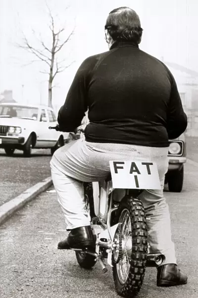 Large man on a small motor cycle with FAT 1 as the licence Number