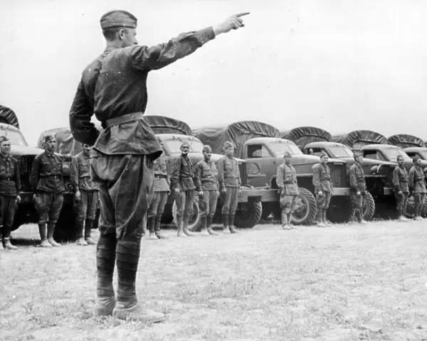 A Russian officer instructing his drivers as they take over Allied vehicles to control